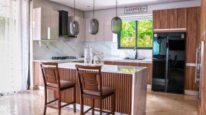 a kitchen with a counter with two chairs at a bar at Ka' Romana Residences in El Soco