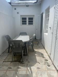 a table and chairs on a patio with a window at Hermoso PH en Necochea playa in Necochea