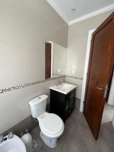 a bathroom with a white toilet and a sink at Hermoso PH en Necochea playa in Necochea +10 photos
