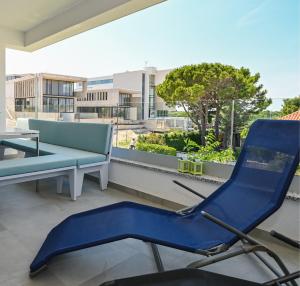 a blue chair and a bench on a balcony at Azuro Novalja Zrce in Novalja