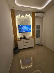 a room with a desk and a large tv on the wall at Villa paradise 360 pantai prigi in Tasikmadu