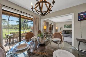 een eetkamer met een glazen tafel en stoelen bij Tee Time Tranquility in Wesley Chapel