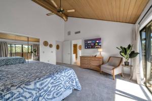 een slaapkamer met een bed, een tv en een stoel bij Tee Time Tranquility in Wesley Chapel +42 foto's