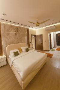 a bedroom with a large white bed with two pillows at Zeta Mall Luxury Apartments by Wall Street Rooftop Pool Access in Islamabad