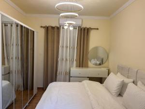 a bedroom with a white bed and a mirror at Modern 3BR Sea & Mountain View Apartment Bouar, Keserwan in Bqāq ad Dīn