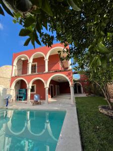 a house with a swimming pool in front of it at Habitacion chica con piscina in Mérida