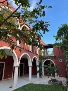 a red building with arches on the side of it at Habitacion chica con piscina in Mérida