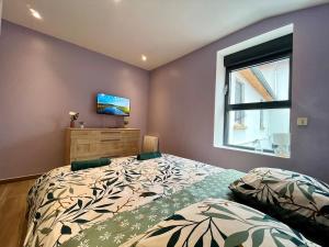 a bedroom with a bed and a window at Le Spacieux gare d'Oullins - 2 chambres - 3 lits - Parking privé in Pierre-Bénite