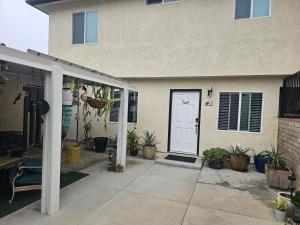 a front door of a house with potted plants at Beautiful new construction 1br with full size appliances centrally located in La Mesa
