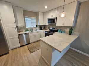 a kitchen with white cabinets and a counter top at Beautiful new construction 1br with full size appliances centrally located in La Mesa