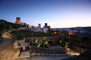 a house on a hill with a city in the background at Casas Do Coro in Marialva