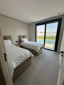una camera da letto con due letti e una grande finestra di Houseselect a Nador