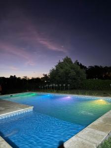 a large blue swimming pool at night at Las Moras saladillo in Saladillo