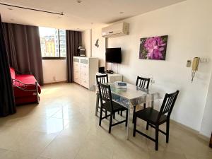 ein Wohnzimmer mit Esstisch und Stühlen in der Unterkunft Bel appartement Kikar Hatzmaout, centre et plage in Netanya