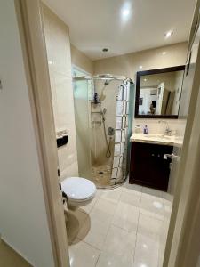 ein Badezimmer mit Dusche, Toilette und Waschbecken in der Unterkunft Bel appartement Kikar Hatzmaout, centre et plage in Netanya