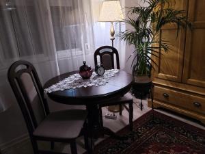 ein Esstisch mit zwei Stühlen und einer Uhr darauf in der Unterkunft Casa Cătălina in Silvaşu de Jos