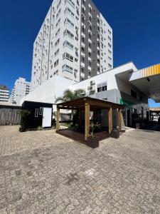 a large white building with a pavilion in front of it at Capão da Canoa - Quarto Aconchegante na Praia! in Capão da Canoa