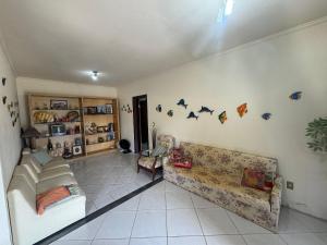 un soggiorno con un divano e dei pipistrelli sul muro di Cód 16 - Casa a pouco a metros do mar a Governador Celso Ramos