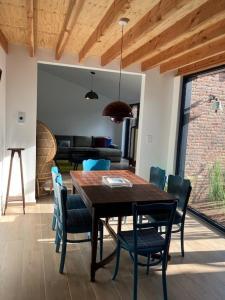 a dining room with a wooden table and chairs at Tampico, Holiday Home at river Schelde in Hamme