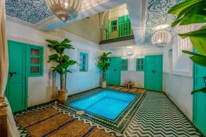 マラケシュにあるRiad Jabador De Marrakechの緑のドアのある部屋にあるプール