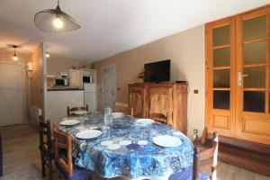 une salle à manger avec une table et des chaises et une cuisine dans l'établissement Sagette, à Laruns