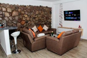 a living room with two couches and a rock wall at Valle Sagrado Mágico in Urubamba