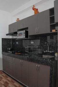 a kitchen with a black counter top with a sink at Valle Sagrado Mágico in Urubamba +17 photos