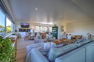 Una sala de estar con un sofá azul y un comedor. en White Penguin, en Stilbaai