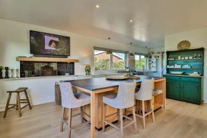 Una cocina con gabinetes verdes y una mesa y sillas. en White Penguin, en Stilbaai