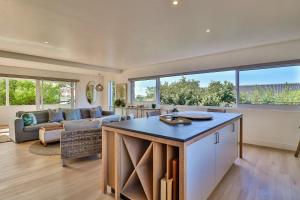 cocina abierta y sala de estar con sofá en White Penguin, en Stilbaai