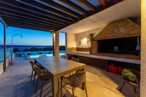 an outdoor patio with a wooden table and chairs at MY DALMATIA - Sea view villa Anpero with private heated pool and sauna in Maslenica