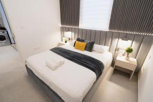 a bedroom with a large bed with white sheets and yellow pillows at One bedroom apartment in Sharjah by Stay Bnb in Sharjah