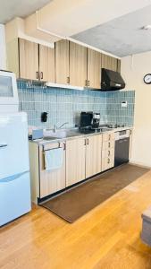 a kitchen with wooden cabinets and a white refrigerator at Stay Narimasu - 3rooms Apartment, 4min to Narimasu station, 1min to Donki in Tokyo