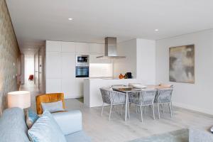 Una cocina y una sala de estar con mesa y sillas. en Land Roots Riverside Apartments, en Vila Nova de Gaia