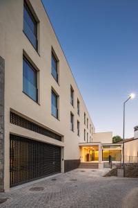 a facade of a building with a garage at Land Roots Riverside Apartments in Vila Nova de Gaia