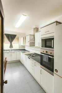 een witte keuken met witte kasten en apparaten bij Apartment Turia Park in Valencia