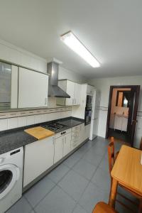 een keuken met witte kasten, een tafel en een fornuis bij Apartment Turia Park in Valencia +12 foto's