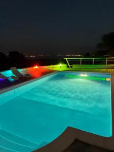 a swimming pool at night with blue lights at Ti-Garence vue mer in Les Trois-Îlets