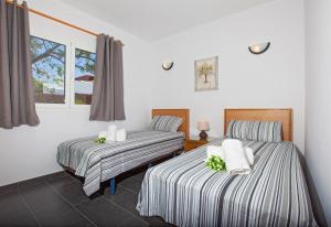 een kamer met twee bedden en een raam bij Villa Esencia in Puerto del Carmen