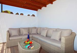 een woonkamer met een bank en een tafel bij Villa Esencia in Puerto del Carmen