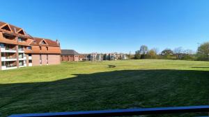 a large grassy field next to a building at PEMATRA FeWo Kleine Brise in Travemünde