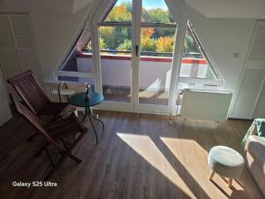 a living room with a large window and a table and chairs at PEMATRA FeWo Kleine Brise in Travemünde
