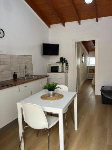 a white kitchen with a white table and chairs at Moya senderos, naturaleza y mar 2 in Moya
