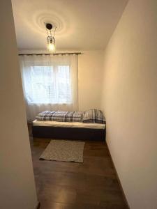 Un dormitorio pequeño con una cama y una ventana. en Relax house Tvarožec, 