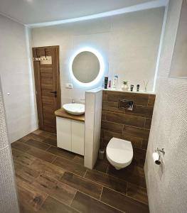 Un baño con inodoro, lavabo y espejo. en Relax house Tvarožec,  2 fotos más