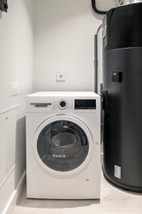 una lavadora y secadora en una cocina junto a una nevera en Land Roots Riverside Apartments, en Vila Nova de Gaia