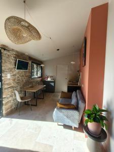 una sala de estar con un sofá y una mesa en La Grange d'Andrea, en Saint-Étienne-de-Fontbellon