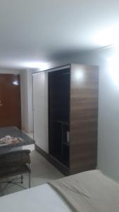 a room with a bed and a door with a table at Blue Sunset Home Service - Angela Hospedagens in João Pessoa