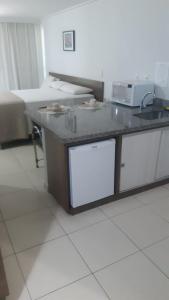 a kitchen with a counter top with a microwave at Blue Sunset Home Service - Angela Hospedagens in João Pessoa
