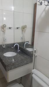 a bathroom with two sinks and a mirror at Blue Sunset Home Service - Angela Hospedagens in João Pessoa
